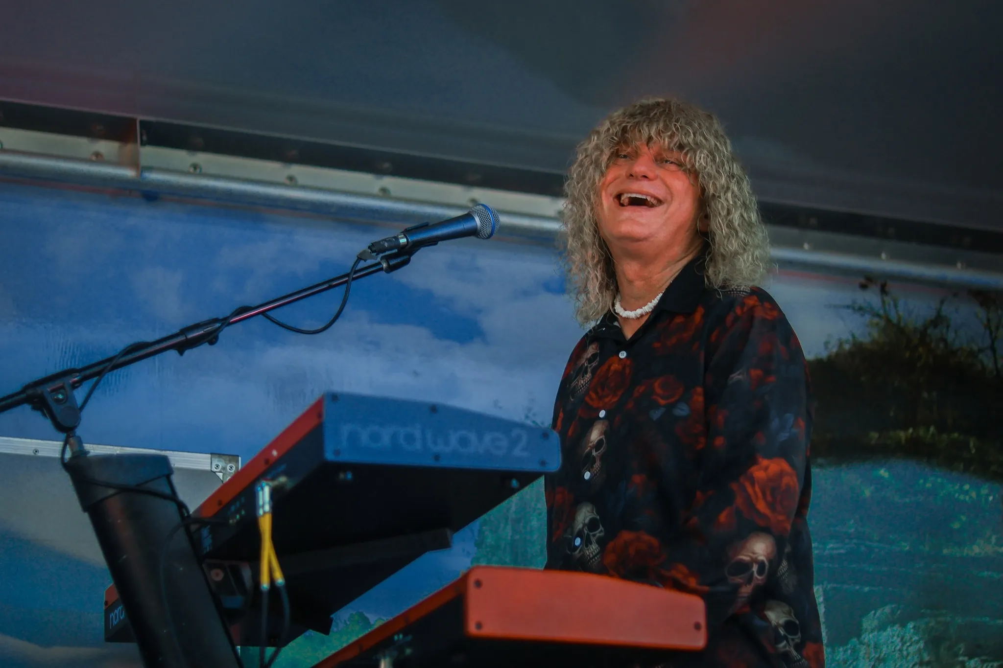 The keyboard player singing at an outdoor show