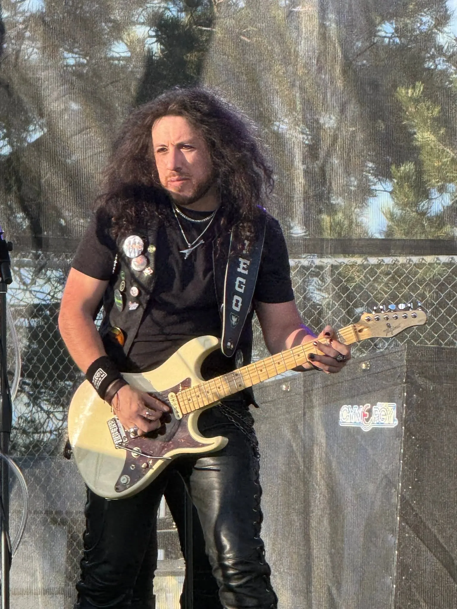 The guitarist playing at an outdoor daytime show
