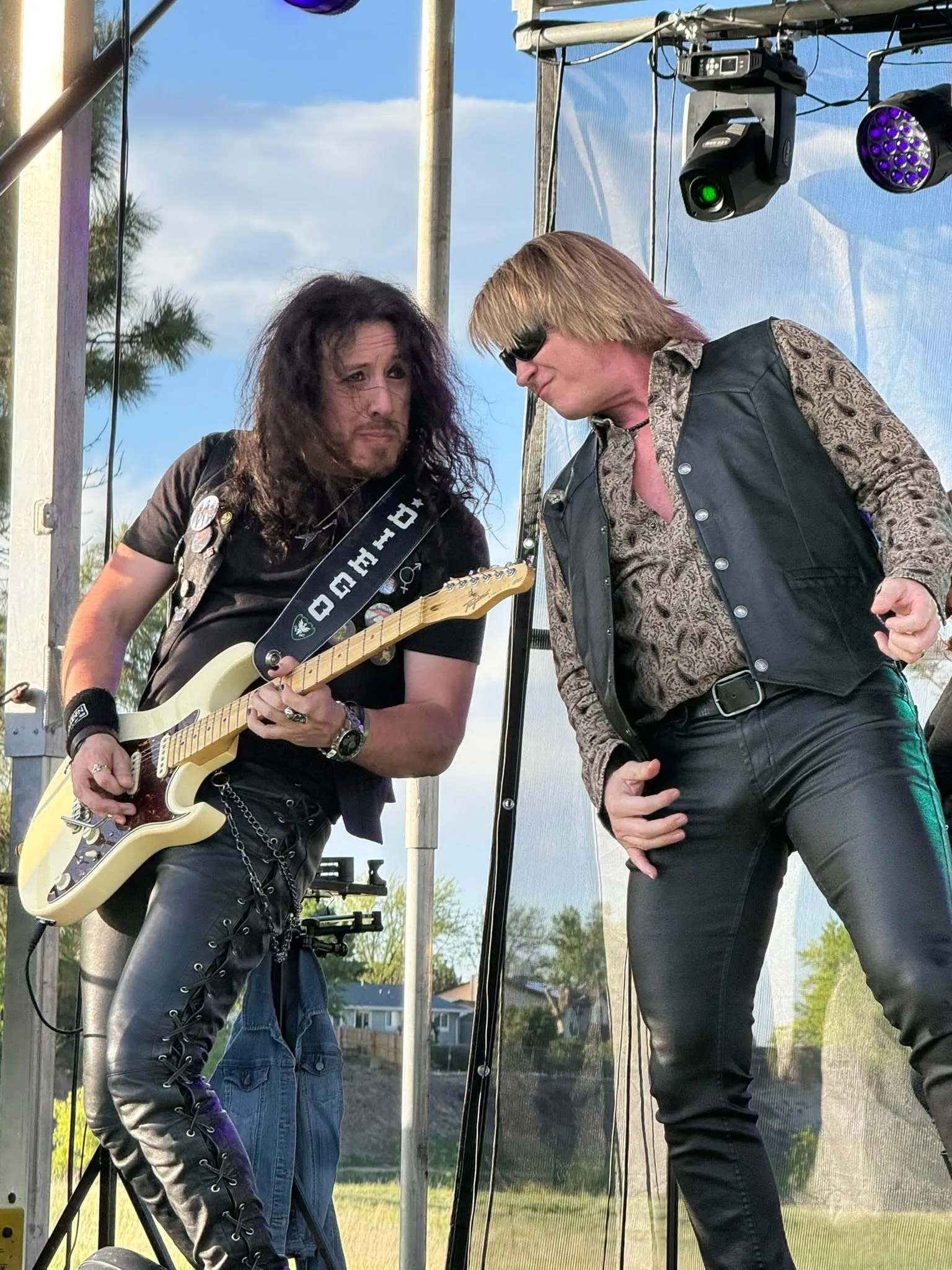 The guitarist and Doug Shepard sharing the mic on an outdoor stage